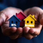 Hands holding miniature houses symbolising buy-to-let brokers and landlord property investment.