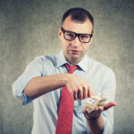 Businessman counting cash money in his hands.