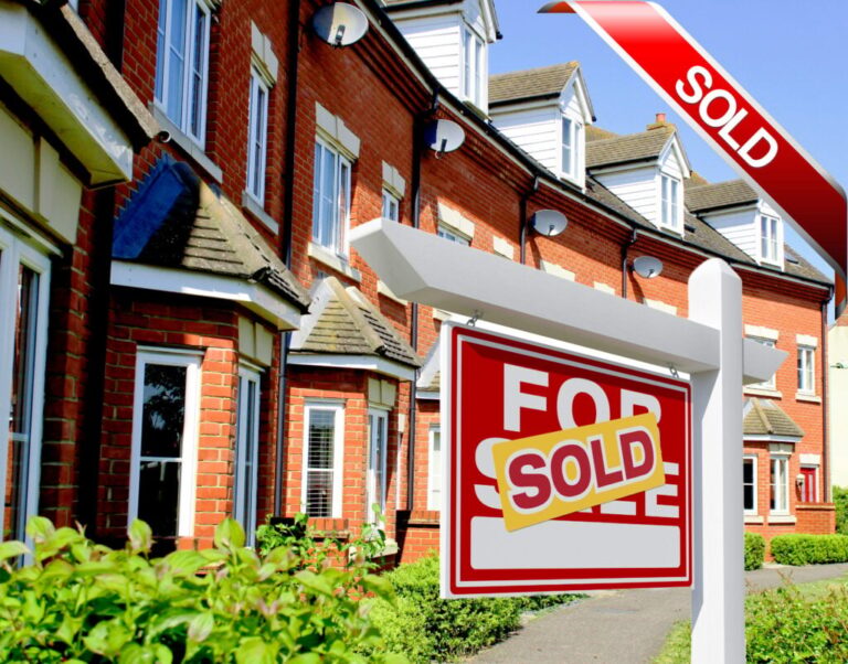 Row of brick houses with a “For Sale” sign marked “Sold” in front garden