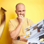 Worried man looks at rising costs and paperwork symbolising landlord concerns over rental reforms.