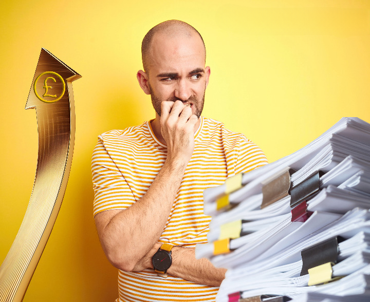 Worried man looks at rising costs and paperwork symbolising landlord concerns over rental reforms.