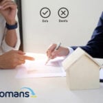 Landlord and agent reviewing property documents and discussing rental management options.