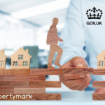 Wooden figure crossing houses on wooden blocks symbolising government support for landlords.