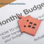 Wooden house icon on a document showing monthly budget figures from the Office for National Statistics.