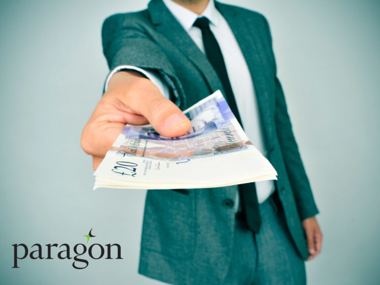 Businessman offering British pound notes symbolising landlord income and property maintenance costs