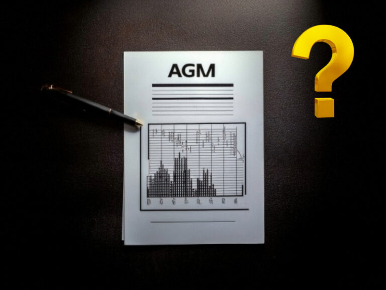 AGM agenda document with financial chart on a desk with pen