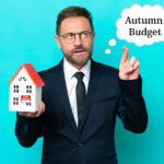 Estate agent holding house model with ‘Autumn Budget’ thought bubble, symbolising property tax uncertainty