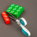Scissors cutting percentage blocks symbolizing mortgage rate reductions