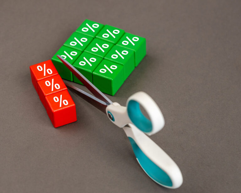 Scissors cutting percentage blocks symbolizing mortgage rate reductions