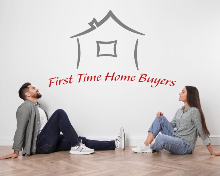 Young couple sitting on floor looking at house outline with “First Time Home Buyers” text.