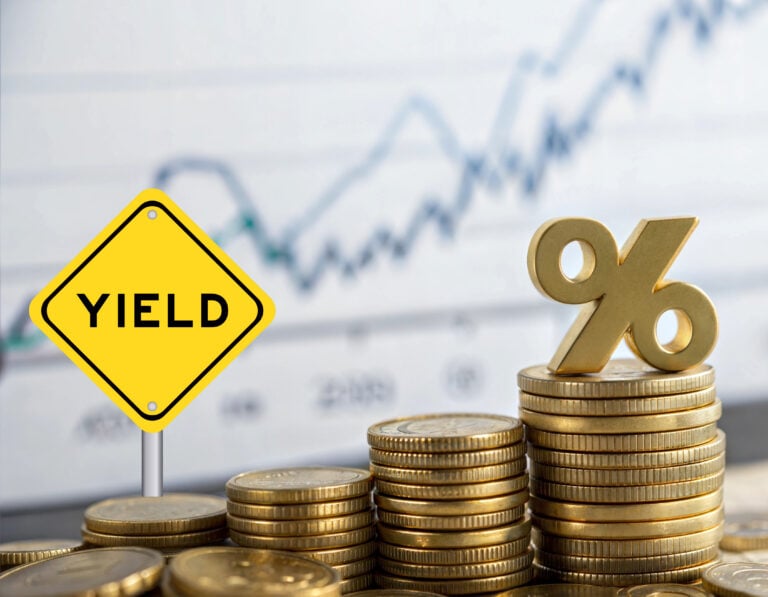 Stacks of coins with yield sign and percentage symbol representing rental yield growth.