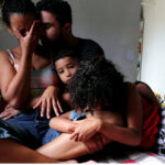 Family in cramped temporary accommodation showing stress and fear of eviction