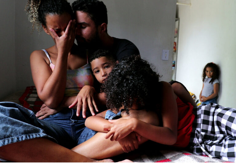 Family in cramped temporary accommodation showing stress and fear of eviction