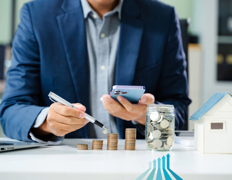 Businessman reviewing housing investment with stacked coins and savings jar.