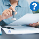 Landlord reviewing documents with a stamp, considering licensing requirements.