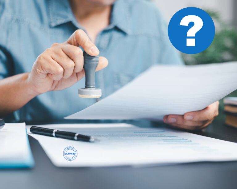Landlord reviewing documents with a stamp, considering licensing requirements.