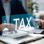 Business professional working on tax calculations with digital tax icons overlay.