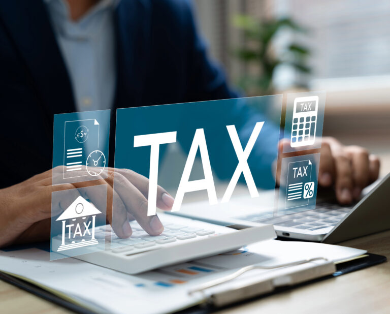 Business professional working on tax calculations with digital tax icons overlay.