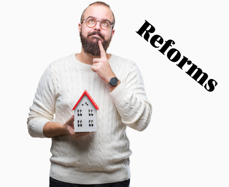 Landlord holding a model house while thinking about planning reforms