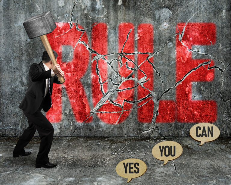 Businessman smashing the word "RULE" on a wall with a sledgehammer, symbolizing breaking unfair rules.