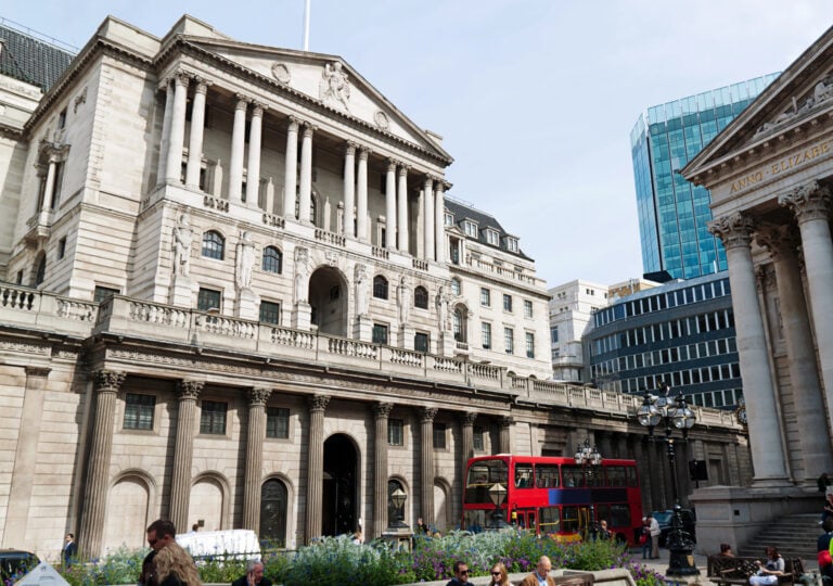 Bank of England building with red London bus in front, symbolising UK property and financial markets