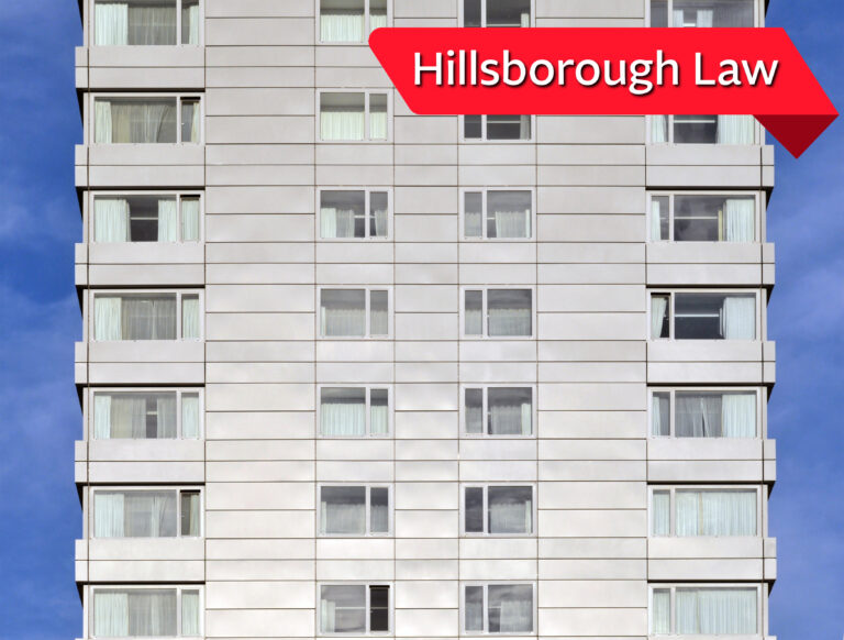 High-rise building with campaign banner promoting Hillsborough Law for cladding scandal justice