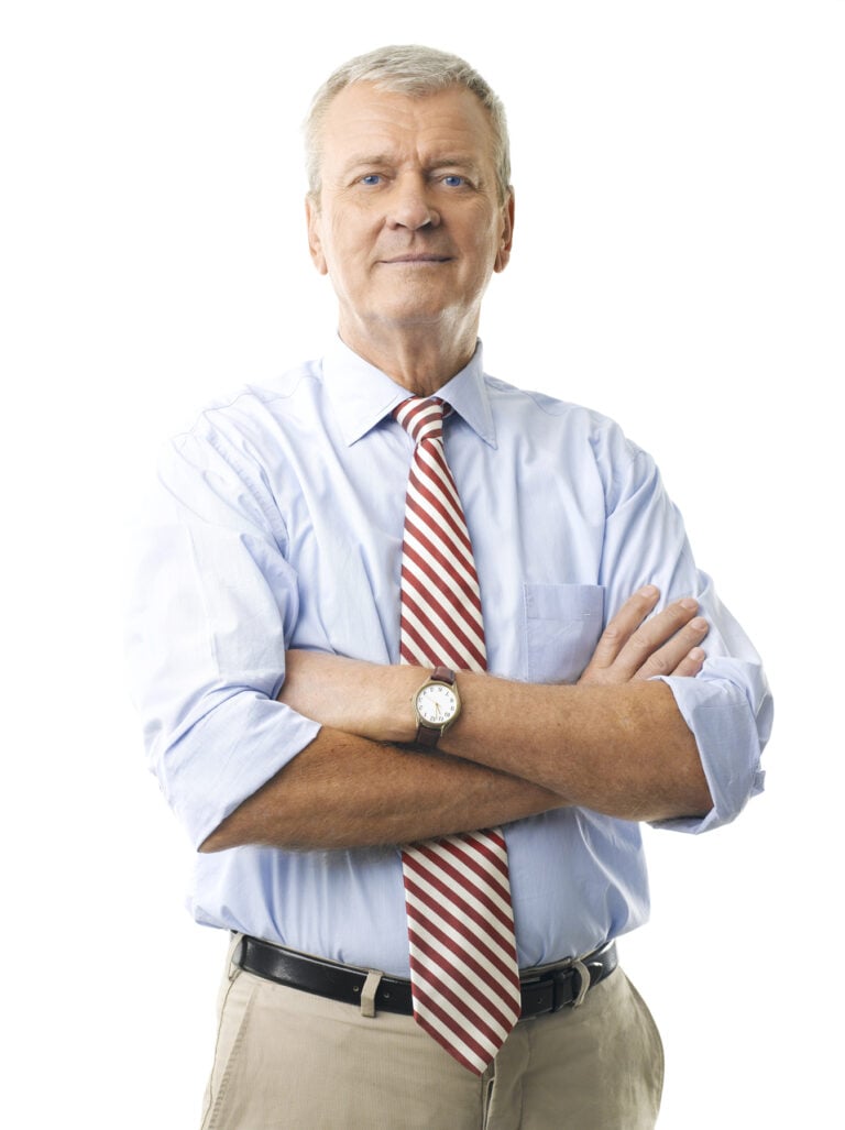 Confident senior man in shirt and tie with arms crossed, symbolizing landlords facing tough property decisions