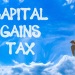 Capital Gains Tax concept with skywriting text and flying bird symbolizing financial freedom and taxation.