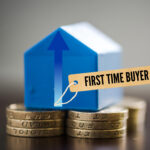 Model house on coins with “First Time Buyer” tag symbolising rising property costs