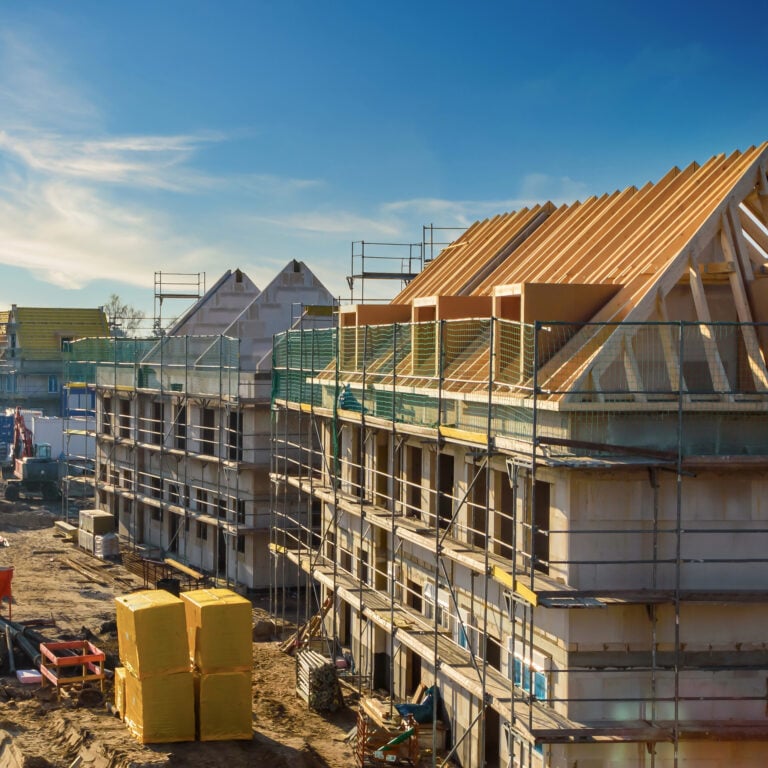 New housing development under construction in London with scaffolding and timber roofs