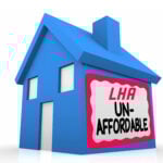 Blue house model with “LHA Unaffordable” sign highlighting the housing affordability crisis.