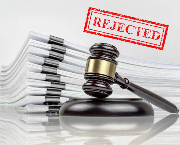 Gavel beside rejected legal documents representing government refusal to review County Court system