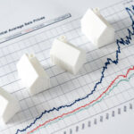 Rising house prices chart with small model homes representing the UK property market.