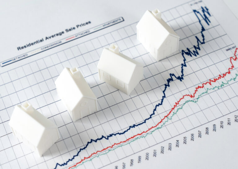 Rising house prices chart with small model homes representing the UK property market.