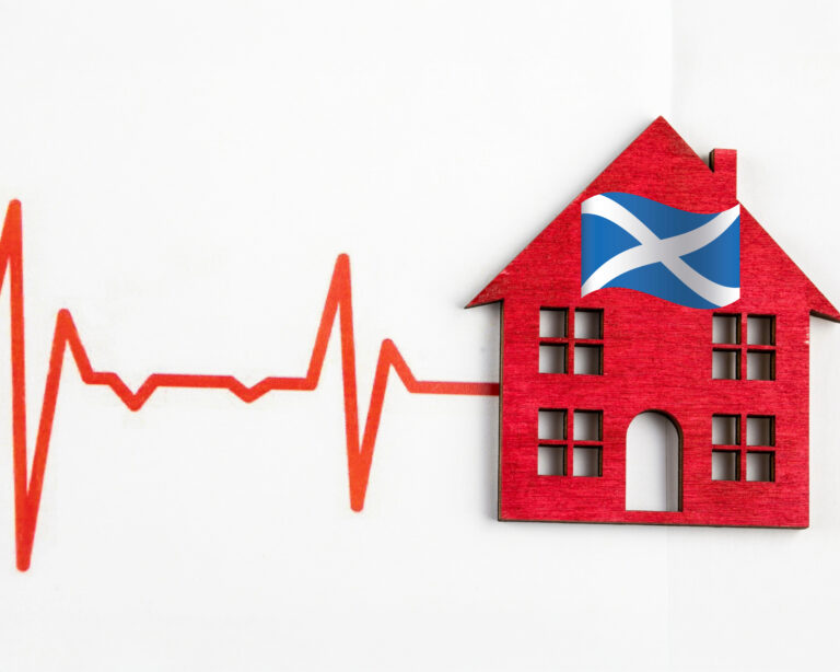 Red house with Scottish flag beside a heartbeat line symbolising Scotland’s housing market health