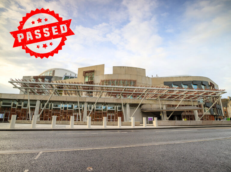 Scottish Parliament building with "PASSED" stamp marking approval of Housing Bill