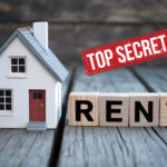 Model house beside wooden blocks spelling rent with top secret stamp.