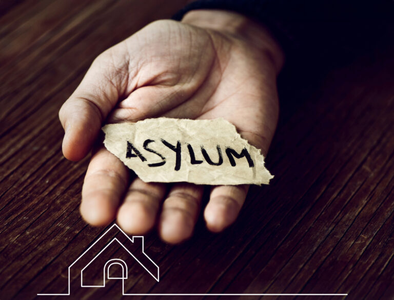 Hand holding torn paper with the word “asylum,” symbolising housing for asylum seekers amid rental market changes
