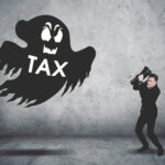 Businessman facing a ghost labeled “TAX,” symbolizing fear of new landlord taxes