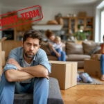 Family surrounded by moving boxes facing uncertainty in short-term housing