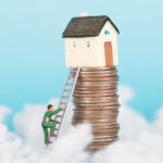 Miniature man climbs ladder toward house atop stacked coins symbolizing rising UK property prices.