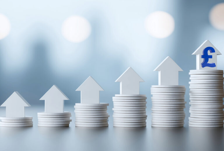 Stacks of coins with upward arrows symbolising rising UK house prices.
