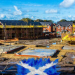 New housing development under construction in Scotland with foundations and scaffolding visible