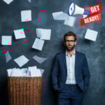Man in business suit standing beside overflowing basket of paperwork with floating sheets symbolising unprepared letting agents