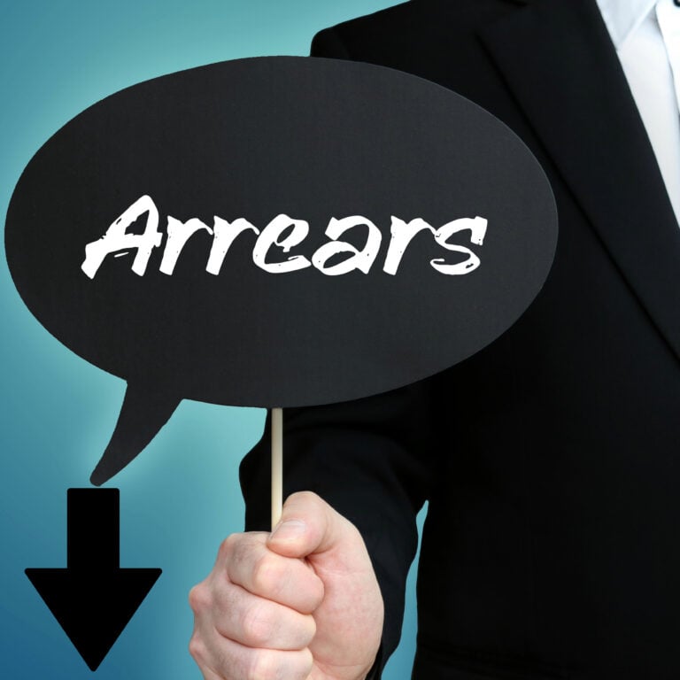 Businessperson holding a sign reading “Arrears,” highlighting mortgage arrears trends
