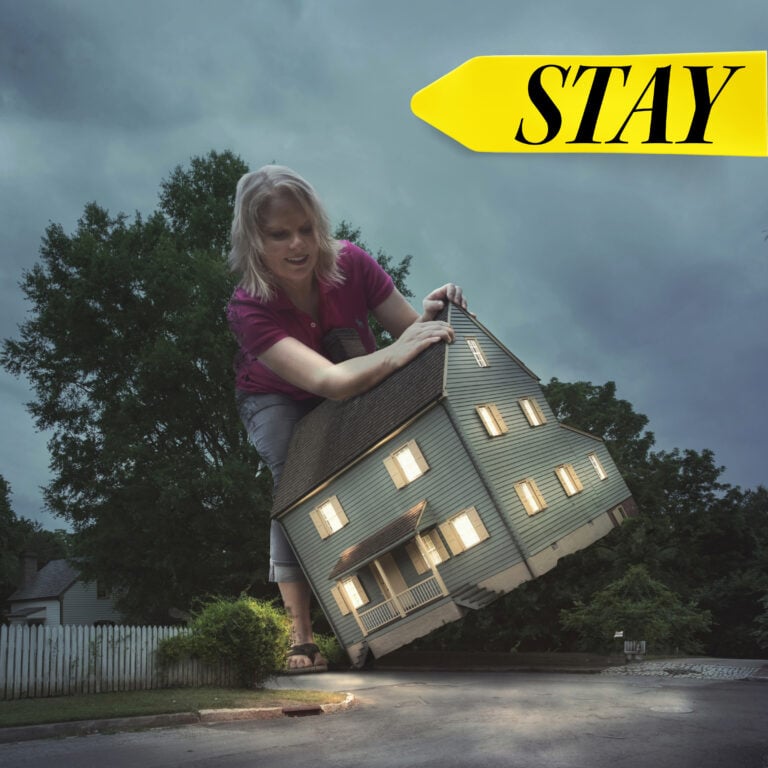 Woman holding a house symbolizing tenants staying put amid rising rents