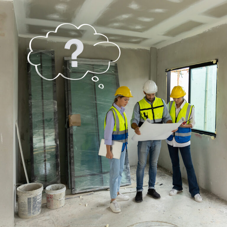 Contractors reviewing renovation plans inside a partially refurbished property