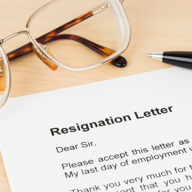 Resignation letter on desk beside glasses and pen symbolizing councillor’s resignation.