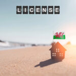 Small house with Welsh flag on a beach symbolising new short-term let licensing rules in Wales