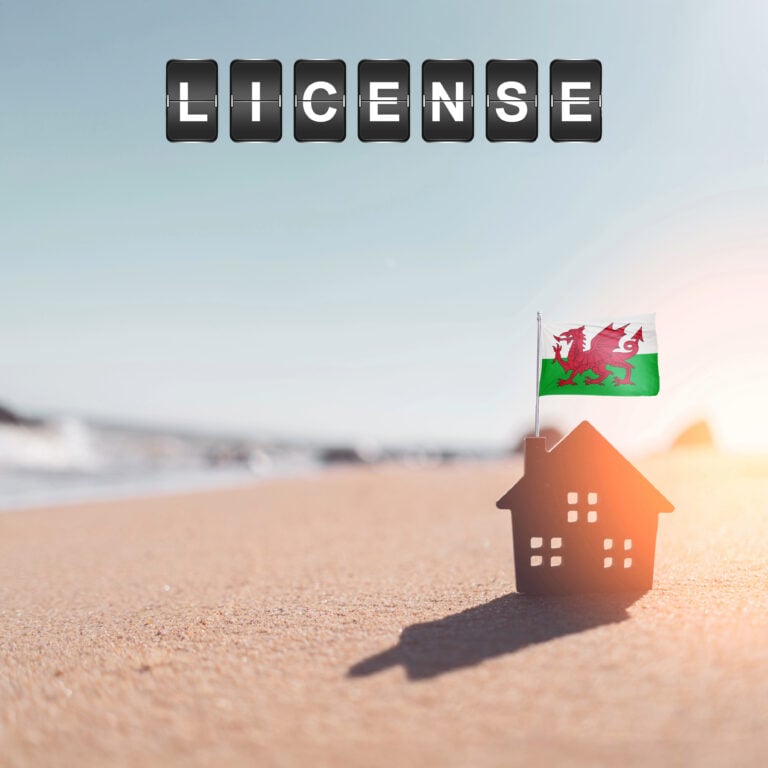Small house with Welsh flag on a beach symbolising new short-term let licensing rules in Wales